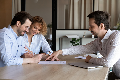 Happy couple of clients signing house buying